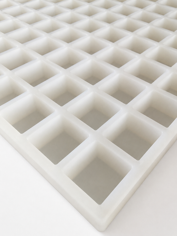 Angled view of a commercial platinum silicone gummy mold showing mold thickness and cavity construction