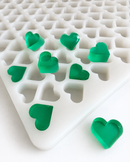 Close-up of 2.76mL heart silicone gummy mold with emerald green heart gummies