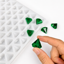 Hand mit smaragdgrünem Diamant-Gummy neben der 2-mL-Form mit 179 Kavitäten