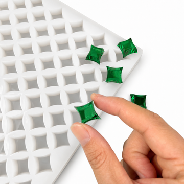 Hand drückt smaragdgrünen Gummy in die 2-mL-Sternform mit 192 Kavitäten