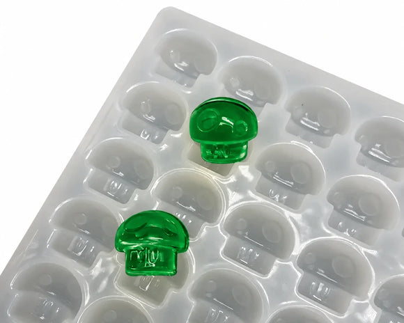Close-up of 3.5mL mushroom gummy mold and emerald green gummy samples