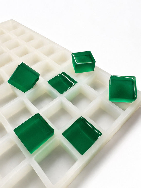 6-mL-Gummiform für quadratische Gummies, 165 Kavitäten — seitliche Schrägansicht; durchscheinende smaragdgrüne Würfel-Gummies; weißer Hintergrund